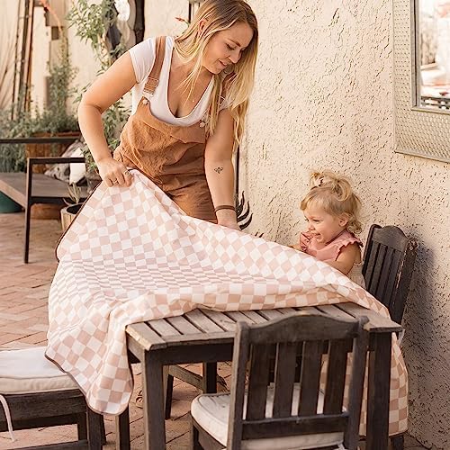 Tiny Twinkle baby floor mat folded compactly next to a packed diaper bag showing portability for travel