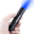 Darkbeam 365 nanometer handheld light revealing dried organic spots on hotel bedding fabric.