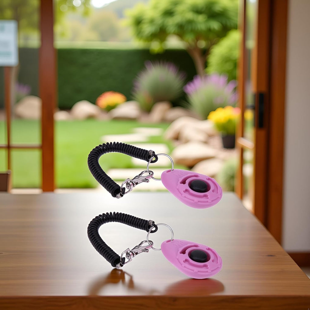 Ergonomic pink puppy clicker held in hand demonstrating training position