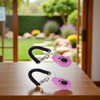 Ergonomic pink puppy clicker held in hand demonstrating training position
