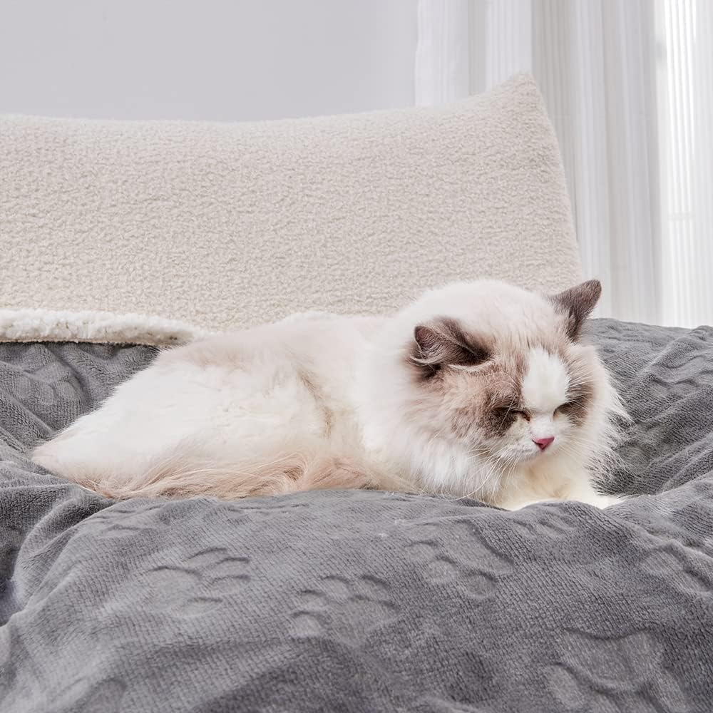 Reversible sherpa fleece cat blanket being used on a luxury bedding comforter
