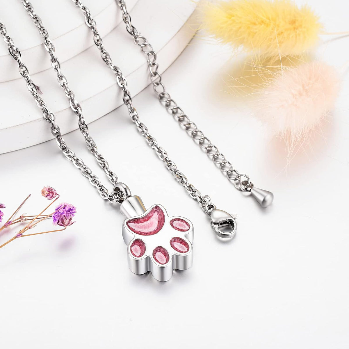 Close up of stainless steel paw print urn pendant for pet ashes