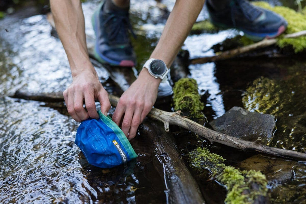 Ruffwear pocket friendly portable dog bowl next to running gear