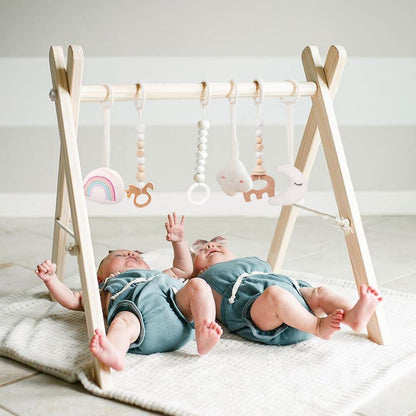 Mallify wooden baby gym front view showcasing the natural pine wood foldable frame and six hanging sensory toys.