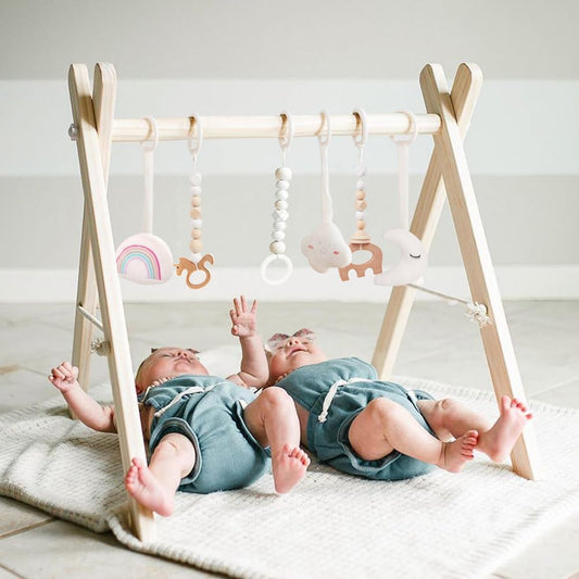 Mallify wooden baby gym front view showcasing the natural pine wood foldable frame and six hanging sensory toys.