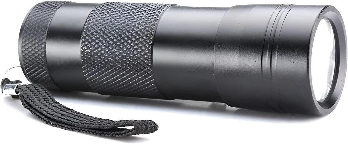 Water resistant portable inspection torch illuminated in a dark room environment.