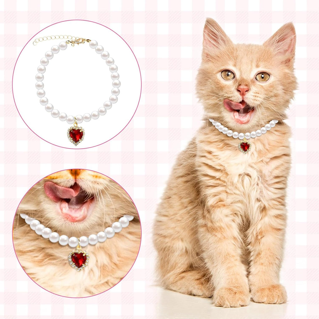 Domestic girl cat dressed in the red heart pearl charm necklace as a wedding dress accessory