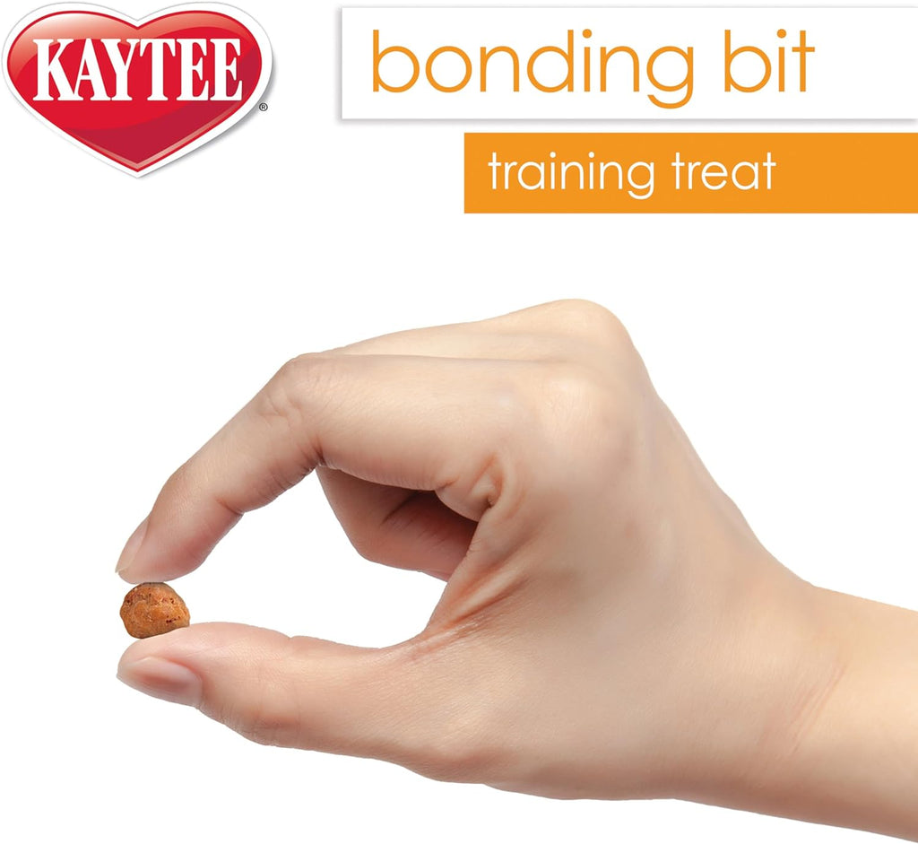 Pet bird eating a Kaytee Bonding Bit from a hand.