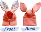 Small dog wearing pink knitted bunny costume hood