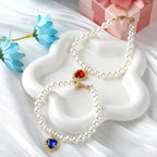 Two piece set of pet pearl jewelry accessories with adjustable extender chain displayed on white background