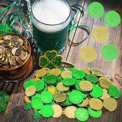 A mix of metallic gold and green plastic lucky coins scattered on a white surface