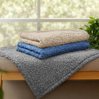 Luciphia machine washable fleece blanket being placed into a home washing machine.