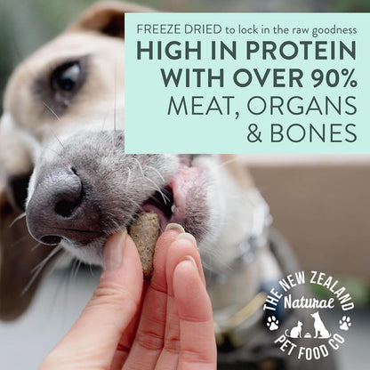 Woof Wild Venison freeze dried nuggets being crumbled over a bowl of dry dog kibble as a healthy topper.