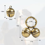 Four premium copper tracking bells with two split rings and leather straps spread out on a clean surface.