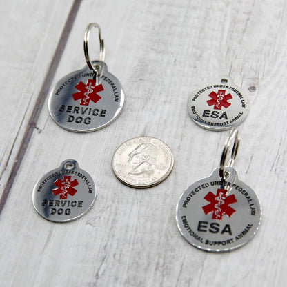 High visibility red enameled emotional support animal identification tag attached securely to a dog harness ring.