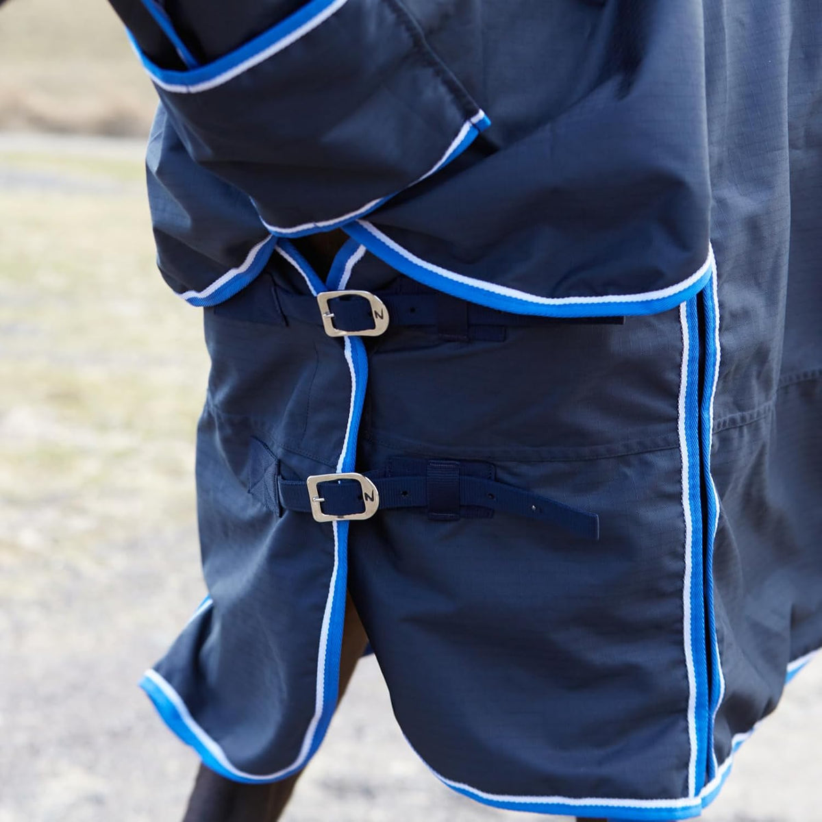 Underbelly view showing cross surcingles and leg straps of Horze turnout blanket