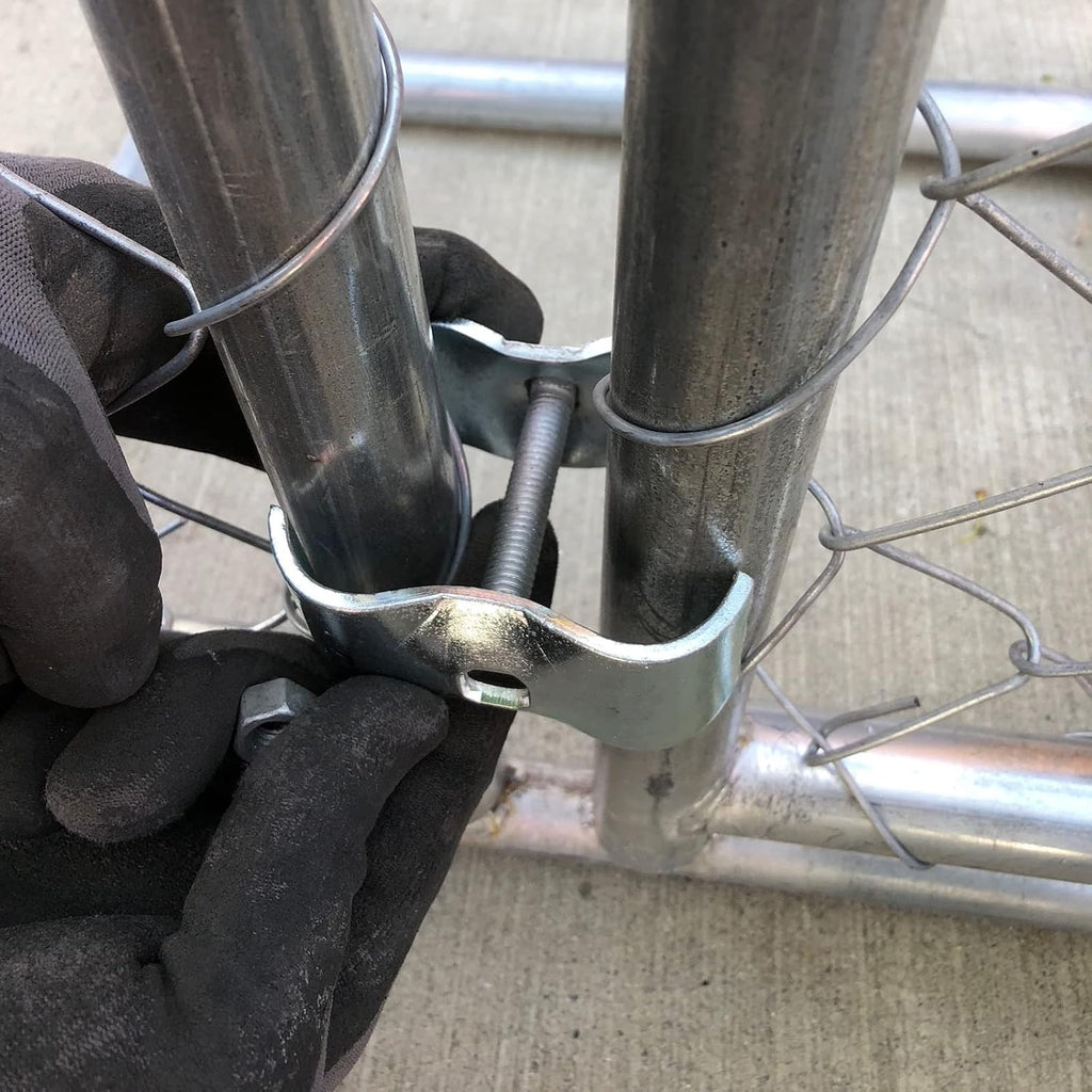 Close up view of a galvanized saddle style clamp wrapping around two parallel round metal pipes.