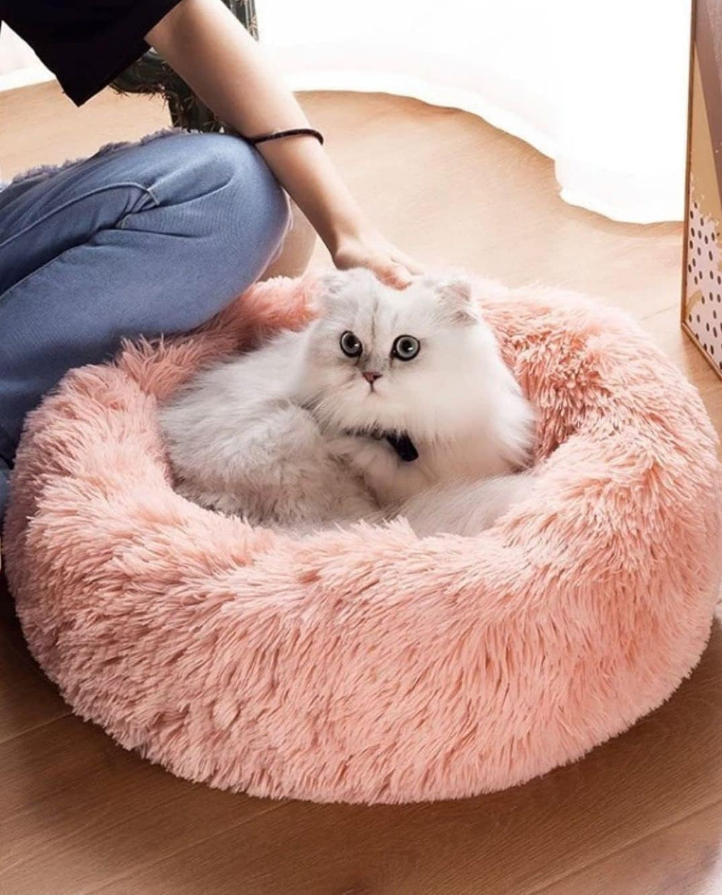 Close up view of soft faux fur texture on pink pet bed