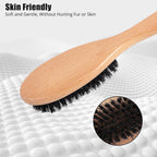 Myselect wooden handle brush being used gently to groom a short haired kitten.