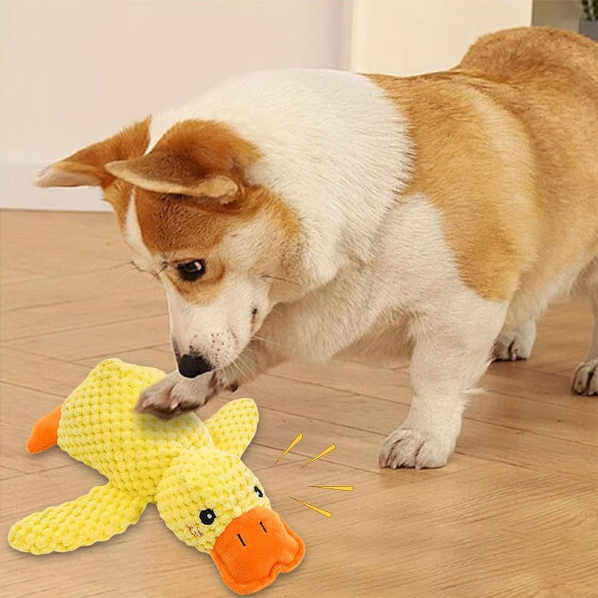 Dog cuddling with yellow duck plush toy on bed