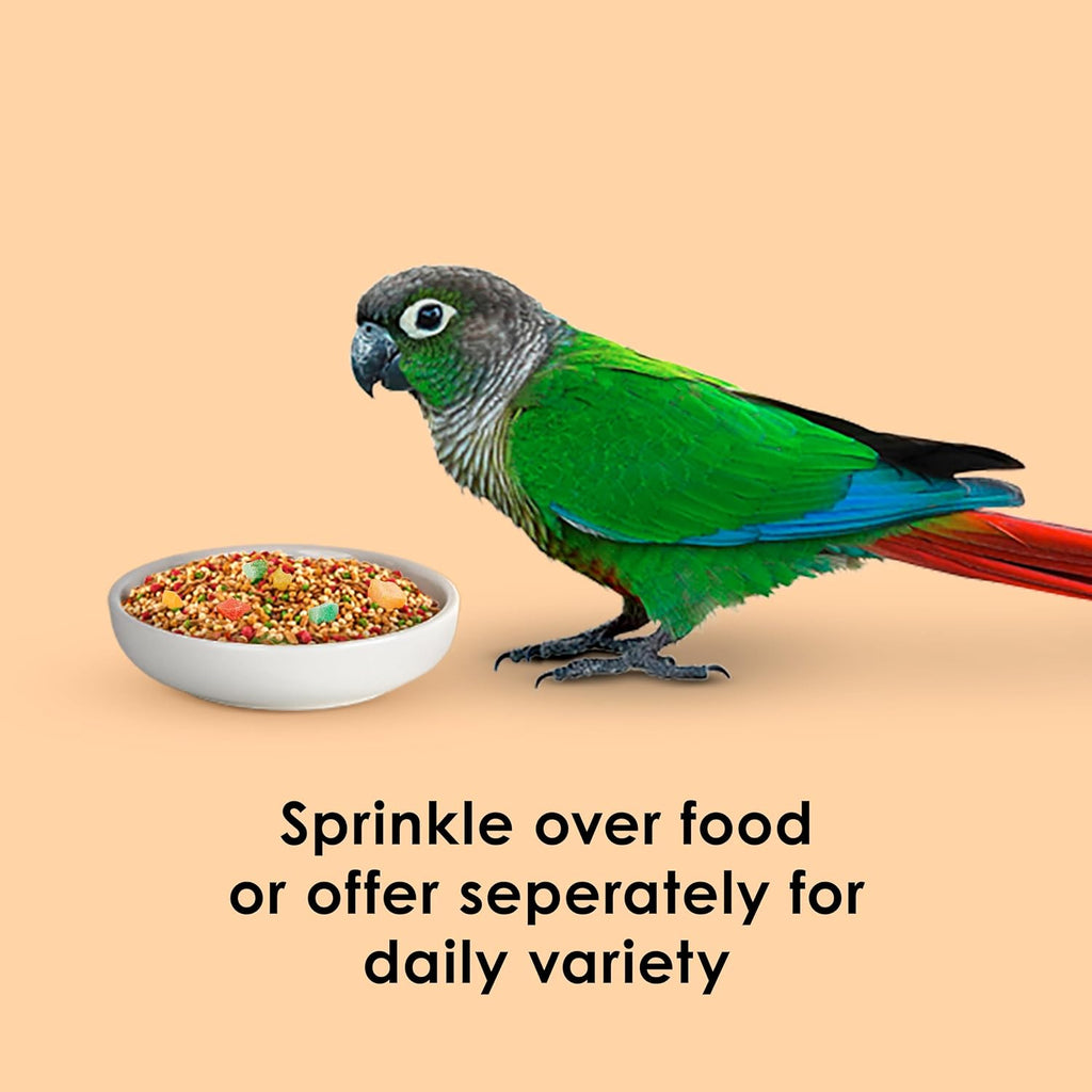 Small parrot eating Kaytee Healthy Toppings Papaya Bits from a bowl