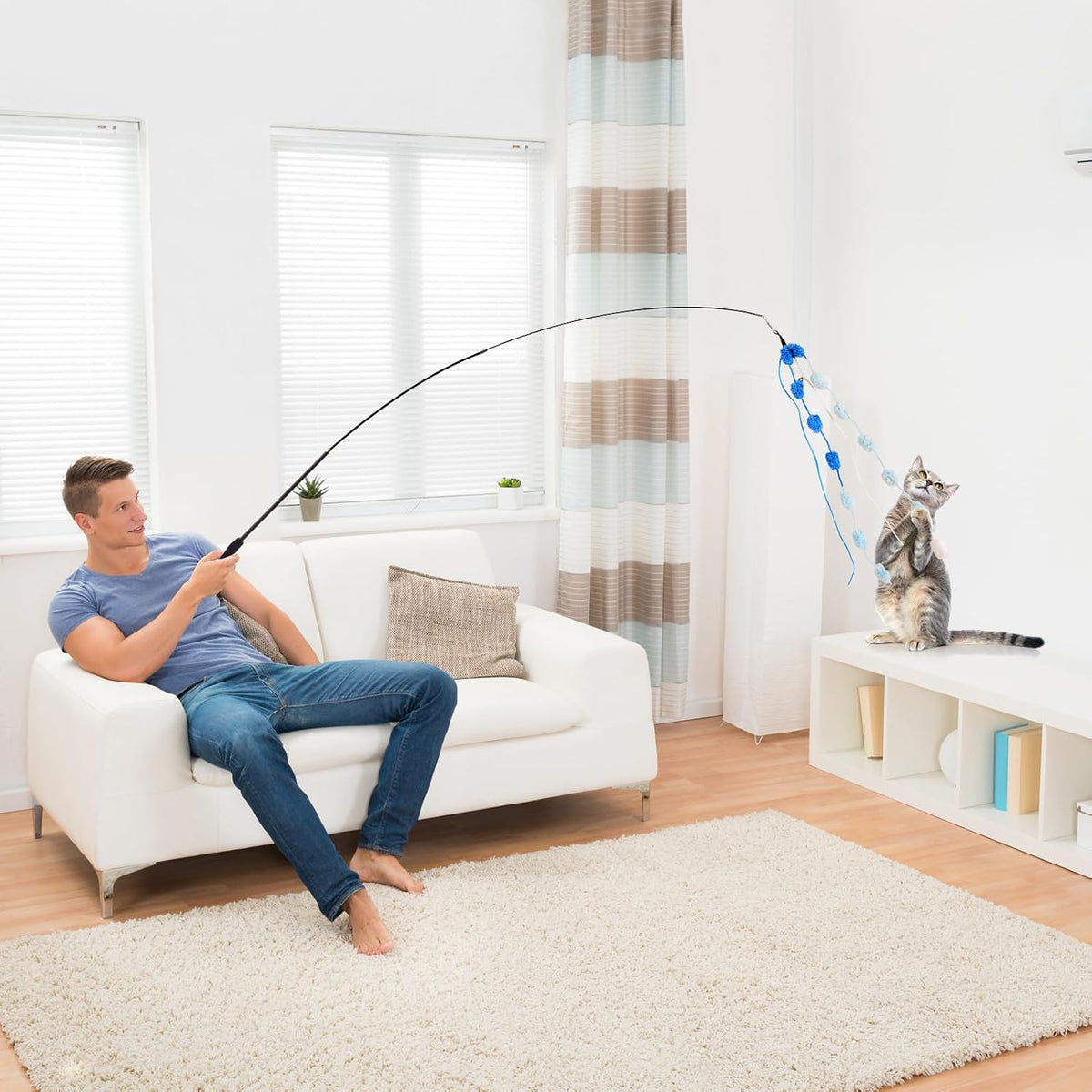 Extendable cat stick toy demonstrating the long string and long distance play reach.