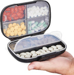 Sukuos Travel Pill Organizer front view showing the sleek black moisture proof outer shell