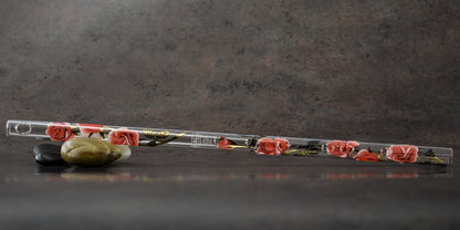 Handcrafted glass flute resting next to its dark green foam lined protective storage box