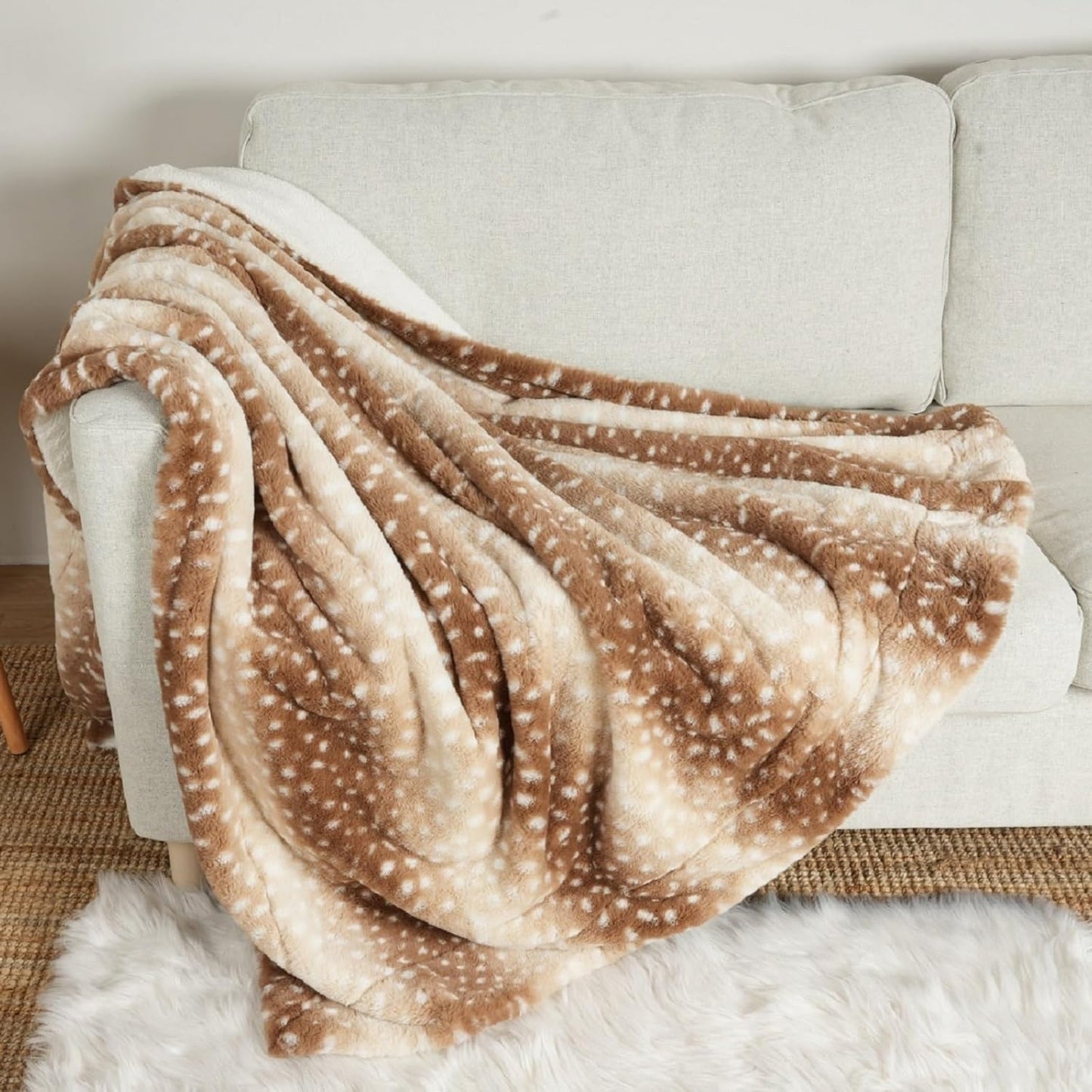 COZY KISS Luxury Faux Fur Waterproof Pet Blanket front view showing brown deer print pattern spread across a sofa.
