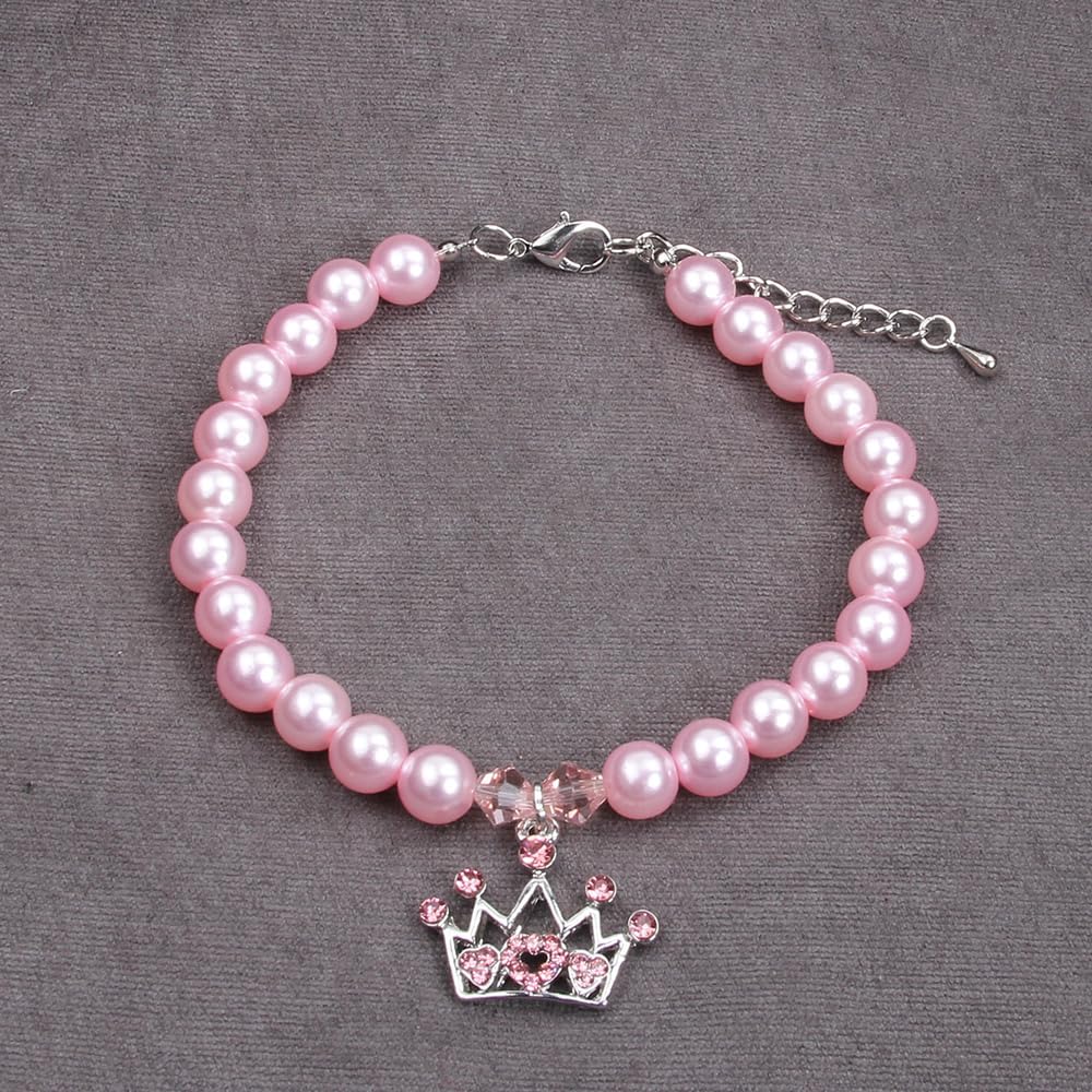 Small puppy wearing a pink pearl necklace with a sparkling rhinestone crown charm