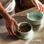 Eco-friendly recycled material pet feeding set in lifestyle travel setting.