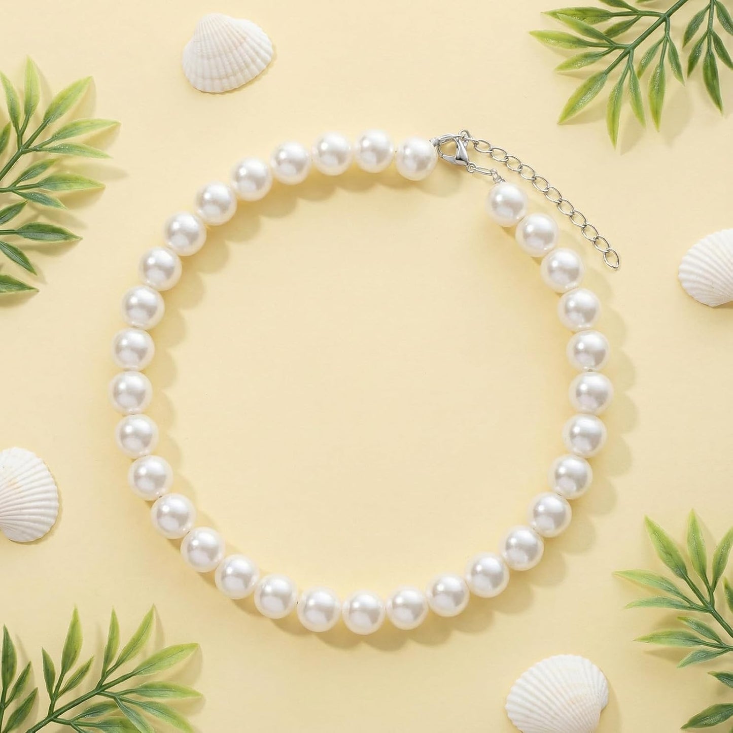 Fengek domestic cat wearing elegant ten millimeter faux pearl costume accessory.