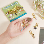 Hand holding enamel pet collar charm to show scale and clasp mechanism