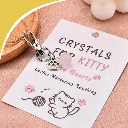 Rose quartz crystal charm on decorative kitten necklace card.