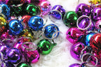 Multi colored decorative puppy and kitten collar bells demonstrating DIY craft applications.