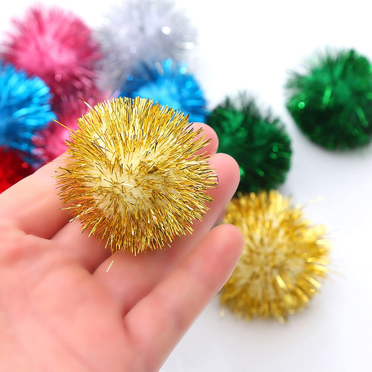 Kitten playing with a two inch green sparkly cat ball toy on carpet
