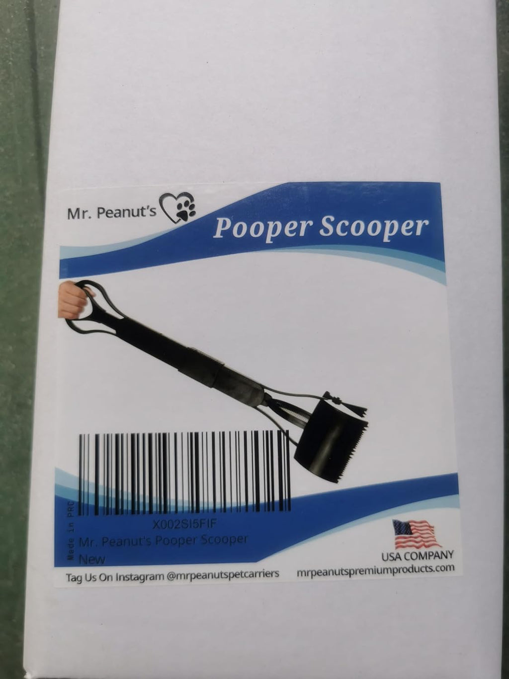 Mr. Peanut's premium imported pet waste management tool working on grass surface.