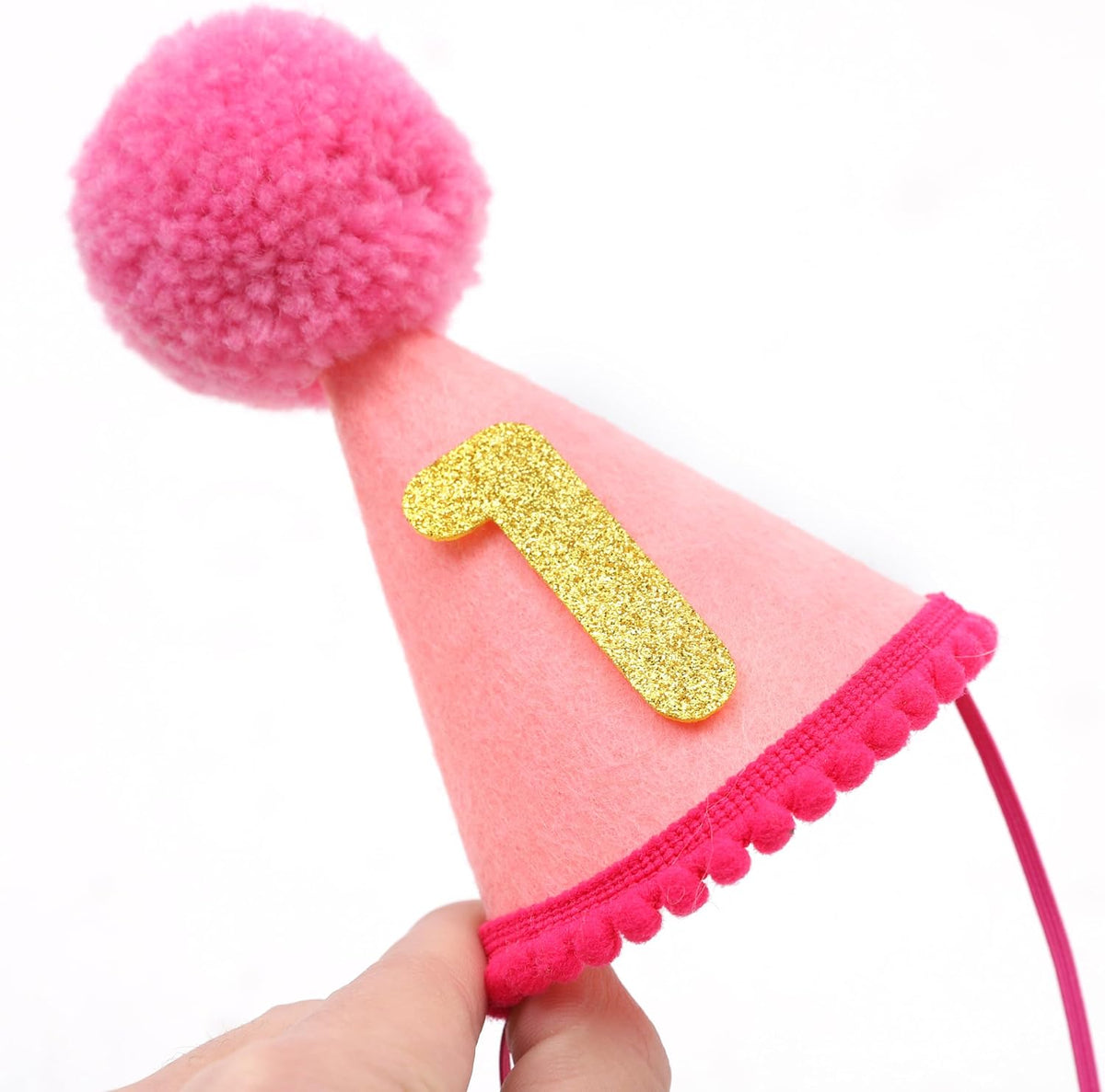 Cat wearing festive pink pet party hat for photoshoot