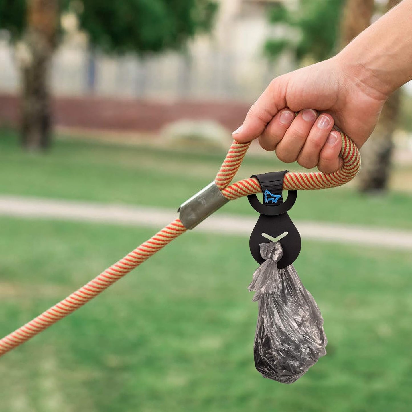 Hands free dog walking accessory holding a knotted plastic waste bag securely