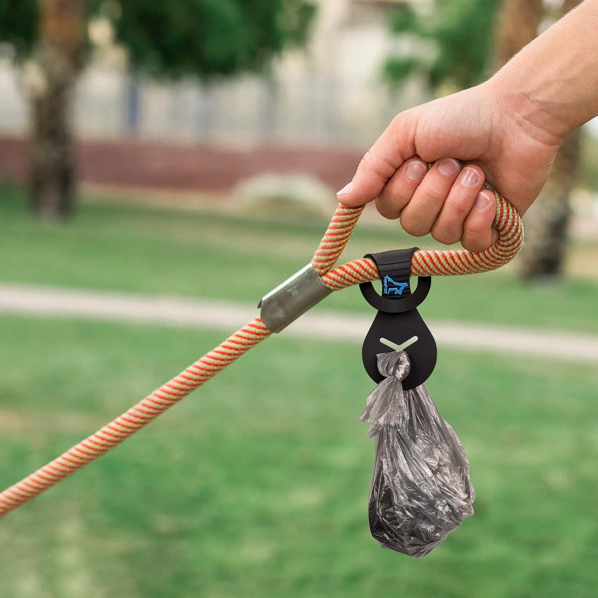 Hands free dog walking accessory holding a knotted plastic waste bag securely