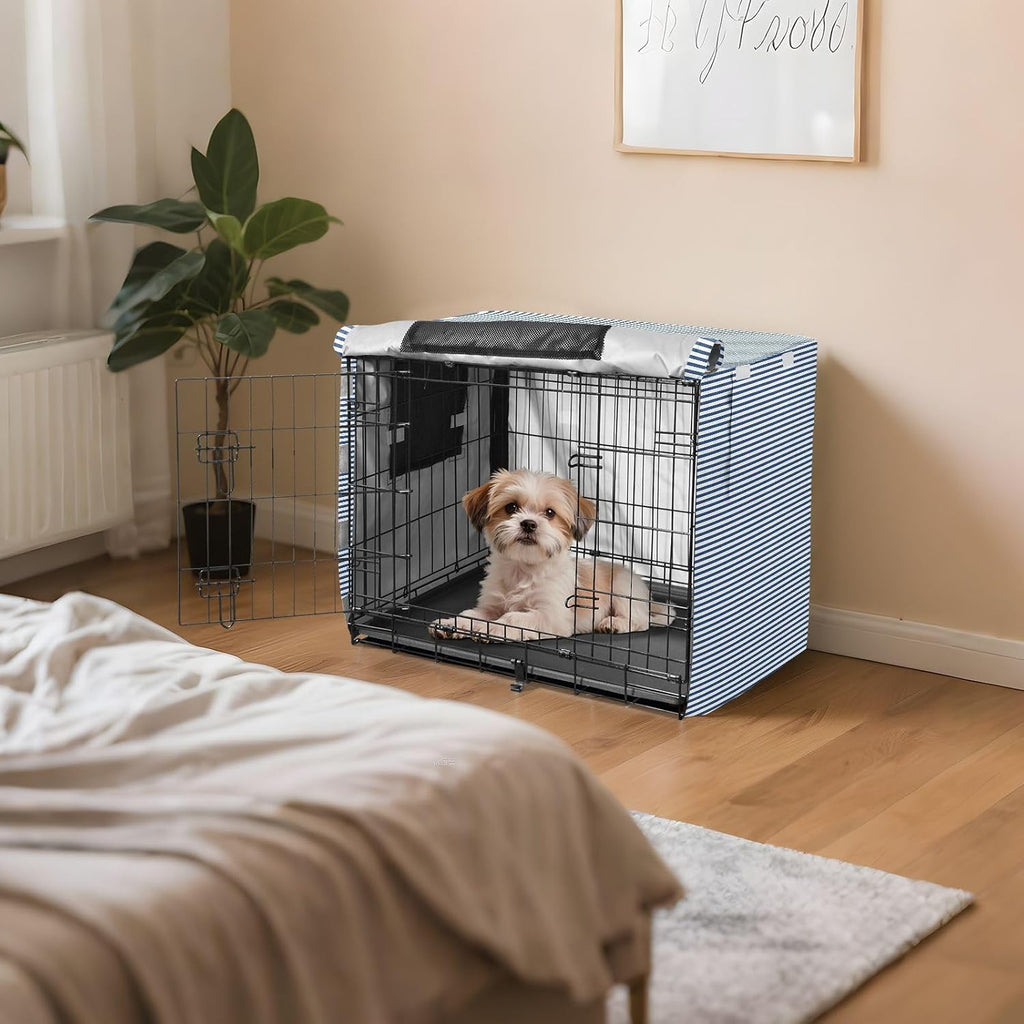 Den-like interior view of a wire dog cage enclosed by the blue striped cover.