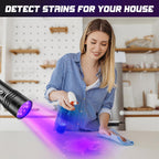 Portable ultraviolet light tool highlighting organic stains in a dark room.