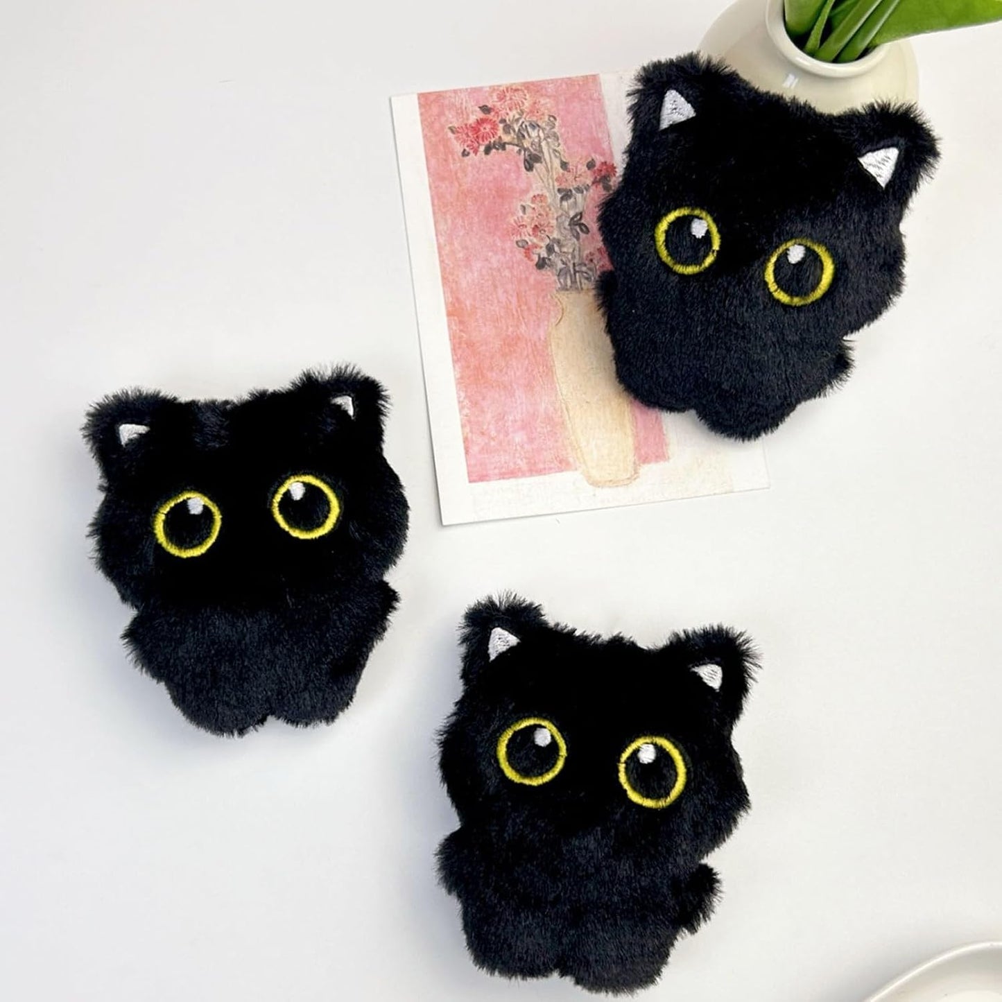 Close-up of the big eyed black cat plush toy showing soft fabric texture