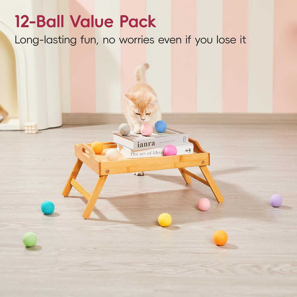 Kitten pouncing on colorful quiet felt ball toy