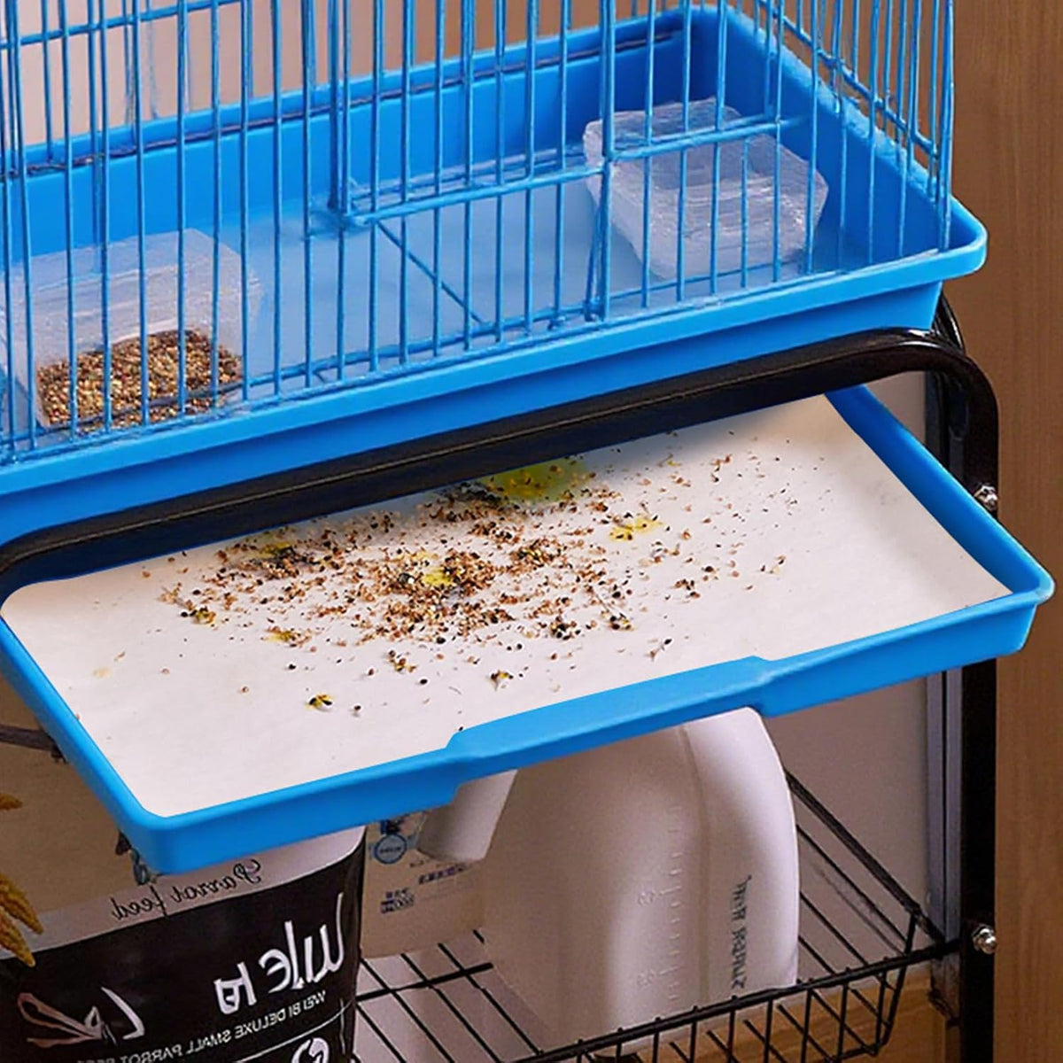 Absorbent non-woven bird cage pad placed inside an aviary tray
