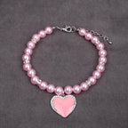 Small pink enamel heart charm with sparkling crystal rhinestones close up.
