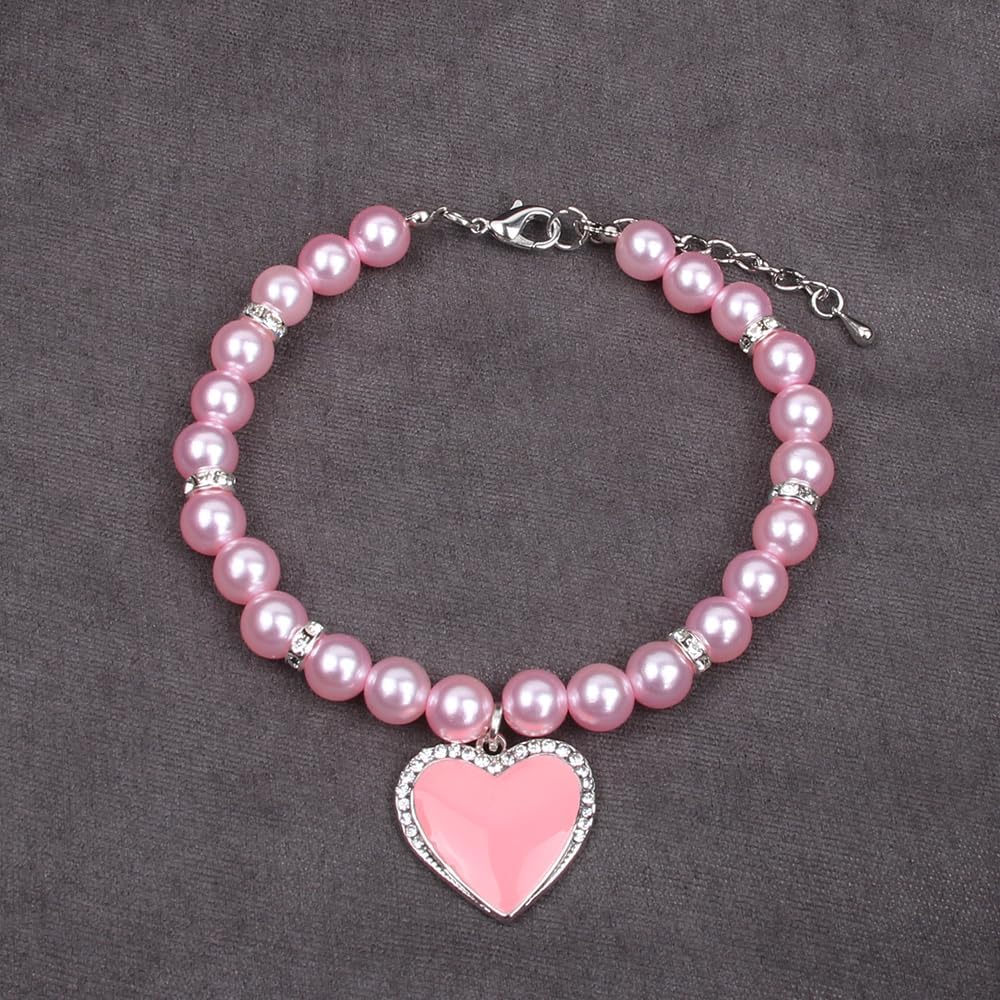Small pink enamel heart charm with sparkling crystal rhinestones close up.