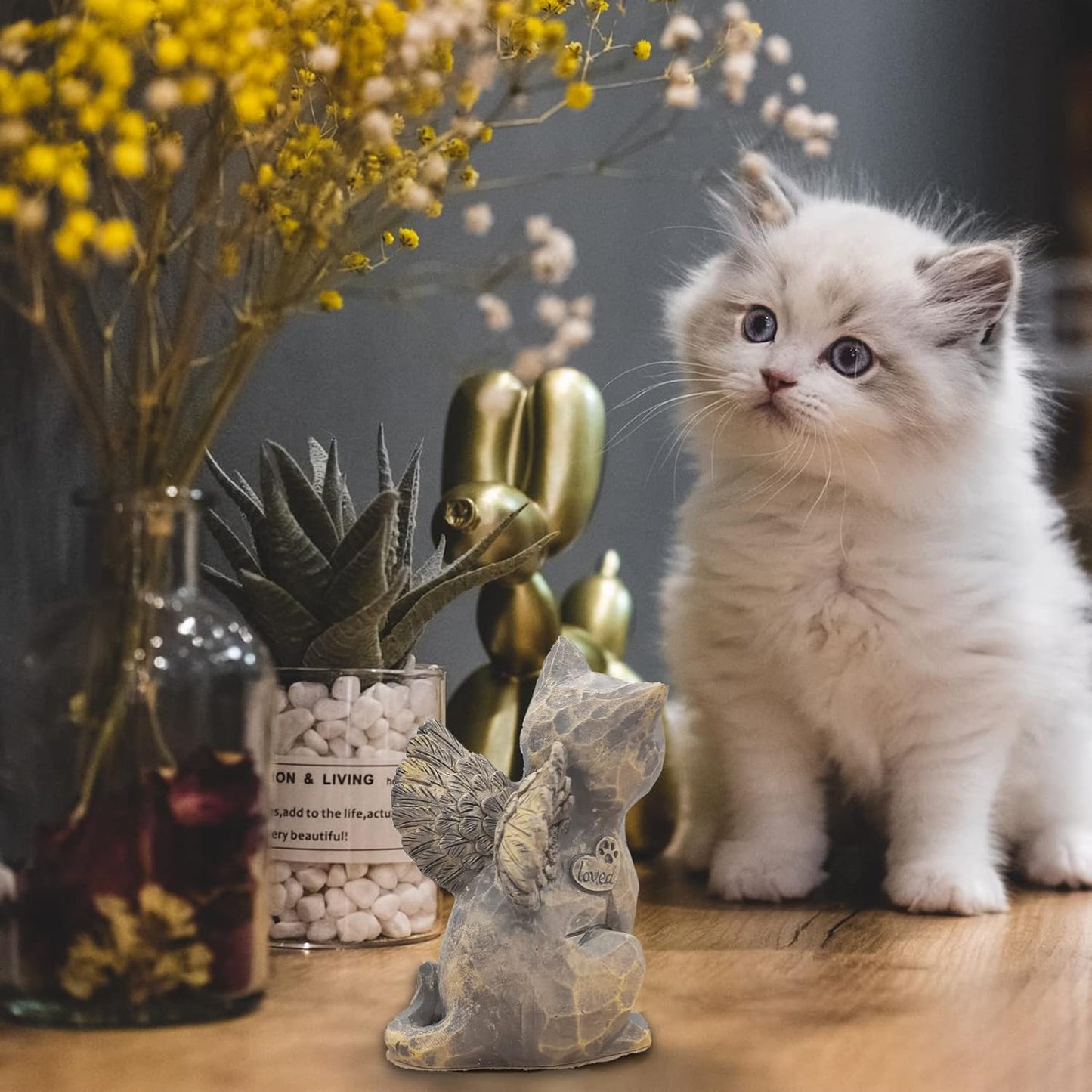 Angled view of the gray cat remembrance statue highlighting the paw print engraving