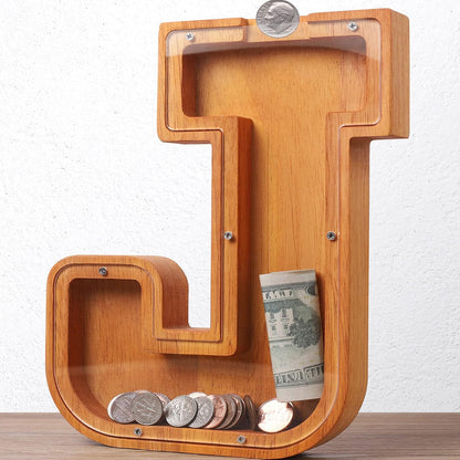 HODNSZRIT wooden letter J piggy bank front view showing transparent panel and coin slot.