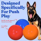 Red hard plastic herding ball for large dogs on grass